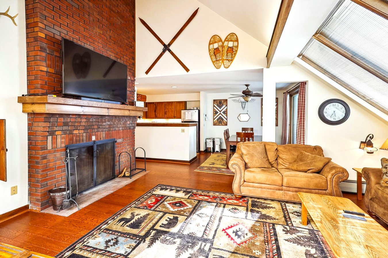 Living room with large fireplace and vintage ski décor hung on the walls. 