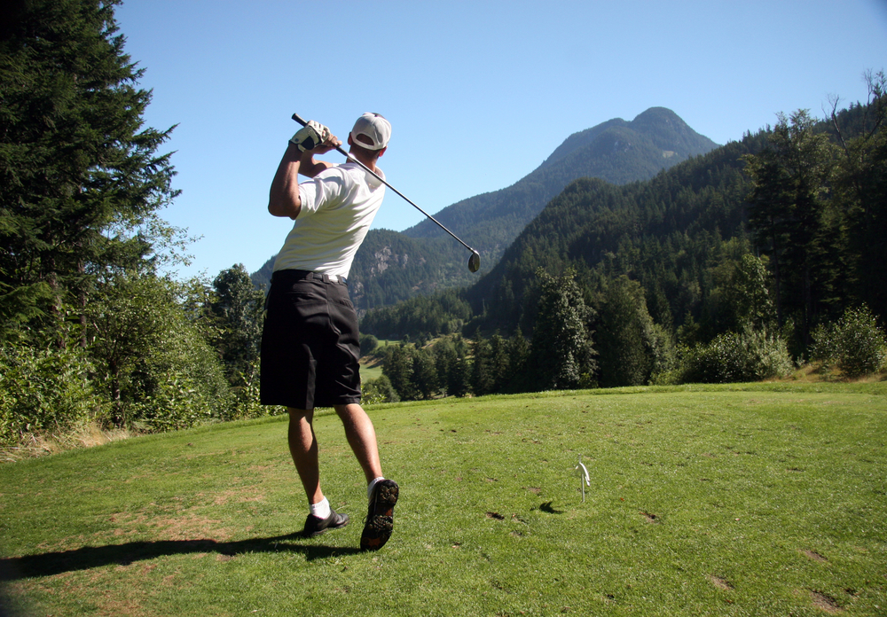 man golfing with a view of the mountains